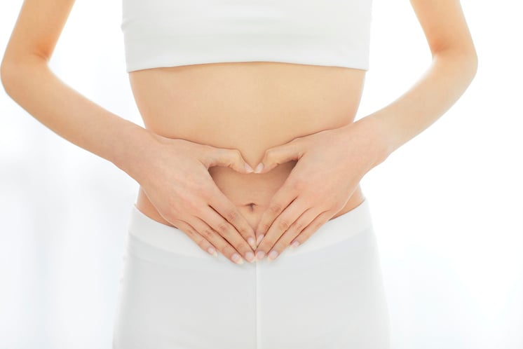 Woman Making Heart Shape with Hands on Belly